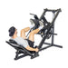 Wearing athletic gear, a person lies on the padded seat of the Bells of Steel Leg Press Hack Squat Machine, pressing the black angled footplate upward with both feet—an ideal addition to any home gym.