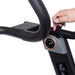 A hand adjusts the resistance knob on the console of the Bells of Steel Blitz Magnetic Resistance Manual Treadmill, featuring handlebars and a digital display.