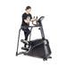 A person in black clothes and a backwards cap uses the Bells of Steel Blitz Stepper for low impact cardio against a plain white background.