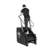 A person in black attire and a beanie uses the Bells of Steel Sisyphean Stepper - Manual Stair Climber with handrails, viewed from behind on a white background—ideal inspiration for your home gym cardio machine setup.